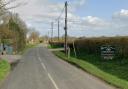 Area - East Road and a sign for Fen Farm Caravan Site on the right