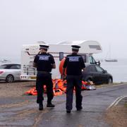 Police officers pass a pile of discarded life jackets at Eastney Point, near Eastney Beach, Portsmouth, following a protest (PA)
